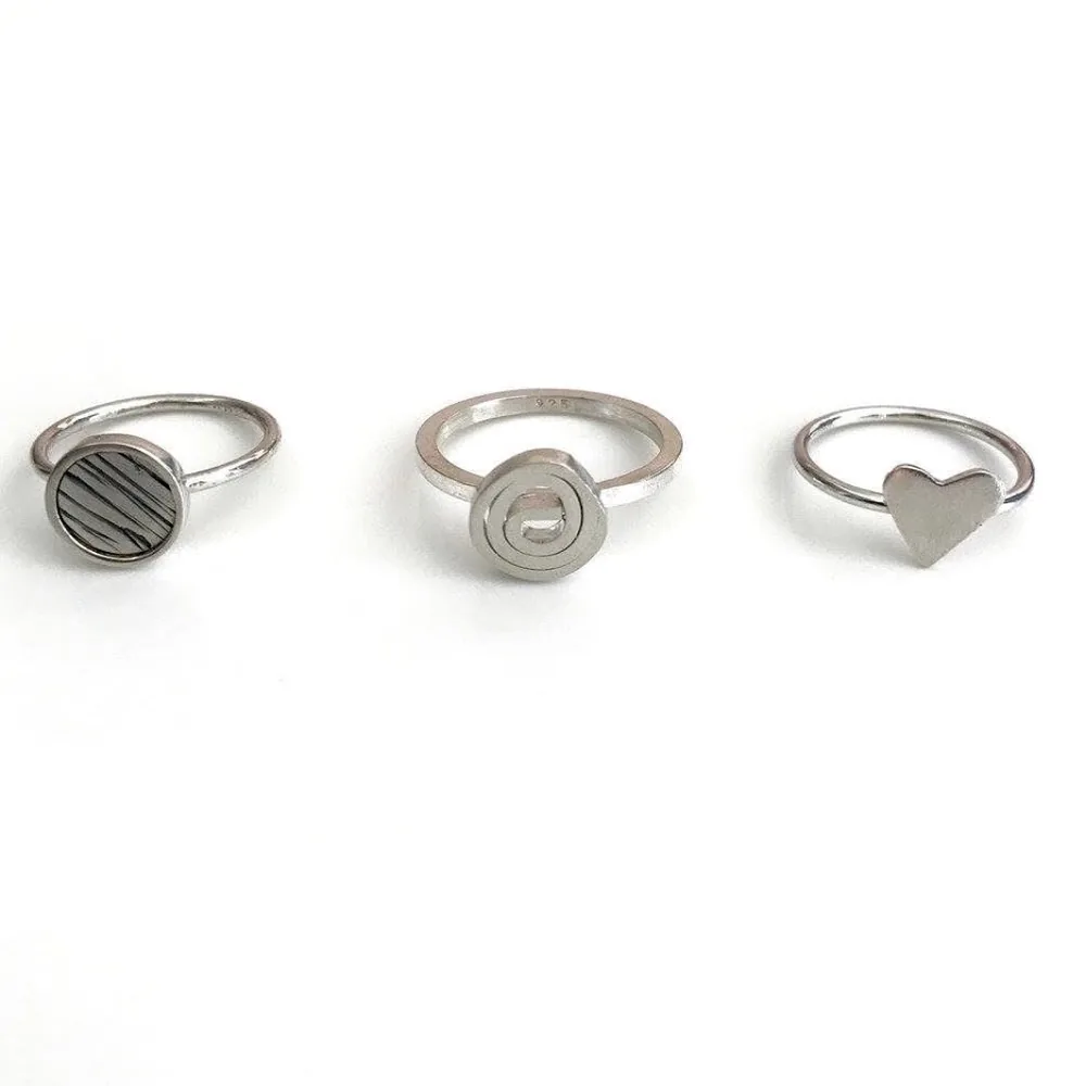 Three silver-tone rings shown together on a clean white background.